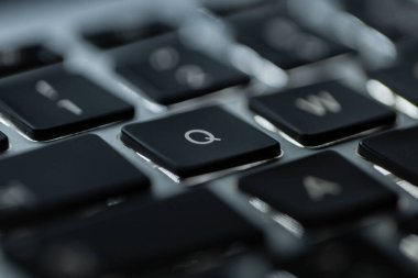Q tuşlu modern arka ışıklandırmalı dizüstü bilgisayar klavyesi, yakın plan. Konsept programlama