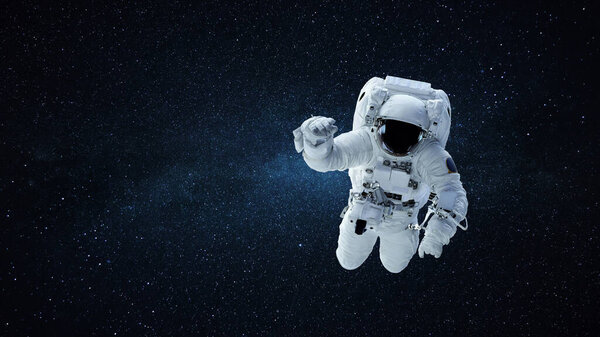 Spaceman in a white space suit with a helmet flies in open space against a background of stars and the Milky Way. Astronaut on a mission in space and travels