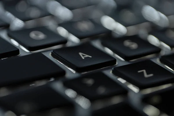 Backlit laptop keyboard, macro. Hacker and technology concept