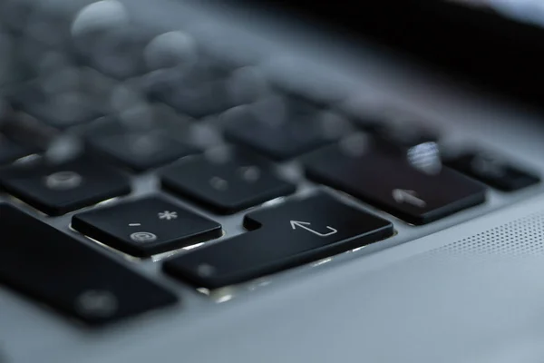 Laptop keyboard with focus on the inter button, close-up. Login and start concept