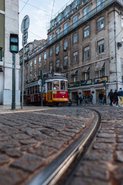 Lizbon. Portekiz - 03 04 2022: yolu ve Coca Cola reklamı olan kırmızı klasik tramvayı olan güzel antik Avrupa şehri.