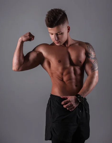 英俊的健美运动员 肌肉发达 身体赤裸 在黑暗的背景下在演播室里摆姿势 健康的身体和饮食 — 图库照片