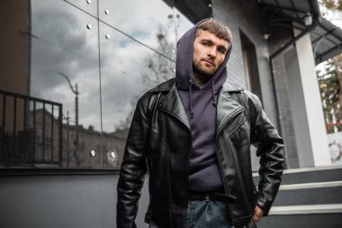 Moda modası geçmiş, siyah deri ceketli ve kapüşonlu bir hippi mankeni.