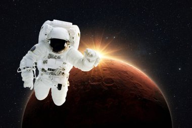 New spaceman flies in gravity in outer space on a backgrounds of the amazing red planet Mars with orange dawn rays in space. Astronaut Journey to the Planet Mars Concept 