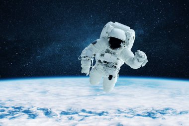 Kasklı beyaz uzay giysili havalı astronot mavi gezegenin üzerinde uzayda uçuyor. Uzay adamı bir görev icra eder ve uzayı keşfeder.