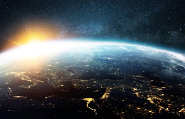 Çok güzel mavi bir gezegen. Güzel turuncu bir gün batımı var. Uzaydan manzaralı. Gündoğumuyla Horizon Dünyası. Derin yıldızlı uzayda gece şehirlerinin ışıklarıyla birlikte. Yaşam konsepti