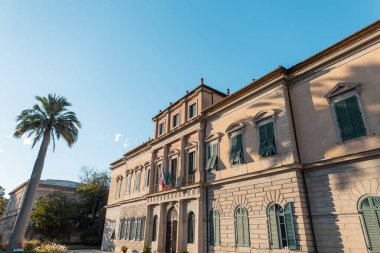 İtalya 'da gün batımında palmiye ağacı olan güzel bir klasik bina. Pisa, İtalya 'da bir Avrupa kasabasında seyahat ve dinlenme