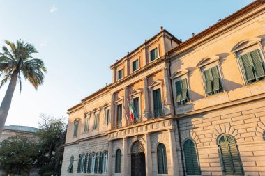 İtalya 'da gün batımında palmiye ağacı olan eski ve güzel bir bina.