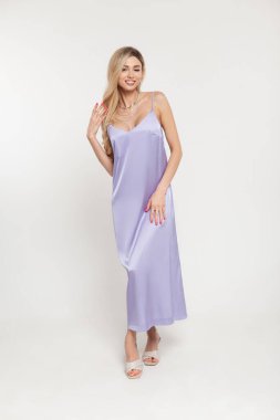 Mutlu moda, güzel, seksi, şık, uzun, kayışlı, ayakkabılı ve beyaz arka planda poz veren sarışın kadın.