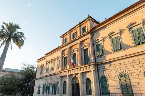 İtalya 'da gün batımında palmiye ağacı olan eski ve güzel bir bina.