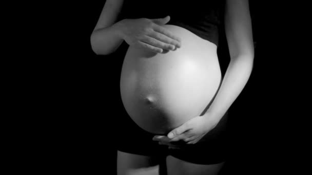 Gravid kvinna gnider magen i svart och vitt — Stockvideo