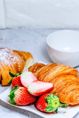 Kruvasan ile Avrupalı kahvaltı. Kahve ve taze çilek.