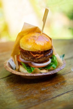 Büyük bir hamburger ahşap bir masaya konur..