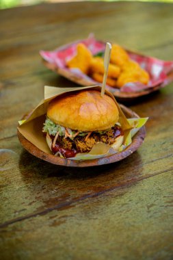 Büyük bir hamburger ahşap bir masaya konur..