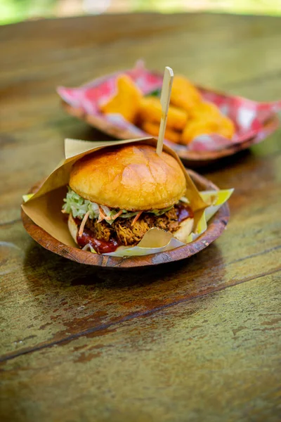 Büyük bir hamburger ahşap bir masaya konur..