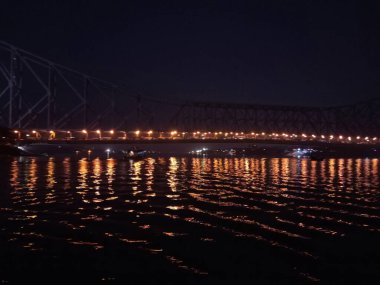 Howrah Köprüsü 'ndeki ışıklar Ganga Nehri' ni altın ışıkla aydınlatıyor. Kolkata 'yı büyülüyor. Bu, Doğu Hindistan Demiryolu Şirketi tarafından 1943 yılında İngiliz Hükümeti tarafından inşa edilen Kolkata 'nın simgesidir.. 