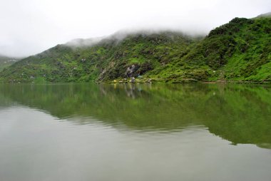 12.600 konumundaki Tsomgo Gölü 'nde yansıtılan yeşil arazi Sikkim, Hindistan' da büyüleyici görünüyor. Arazi Nisan ayına kadar karla kaplıydı ve Mayıs ayından itibaren eridi ve burası bölgenin en popüler turistik yeridir.. 