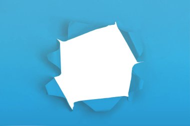 Beyaz arka planda delik olan mavi kağıt. Kopyalama alanı olan arkaplan kavramı.