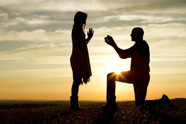 Sunset silhouette marriage proposal - Stock Image - Everypixel