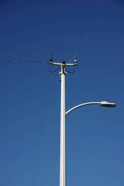 Een Moderne Electriciteitspyloon Met Elektriciteitsleidingen Een Straatlantaarn Onder Blauwe Hemel — Stockfoto