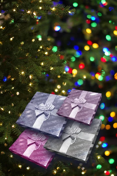 圣诞贺卡上有包装好的礼品盒和装饰好的人造圣诞树 圣诞树上的彩灯模糊不清 — 图库照片
