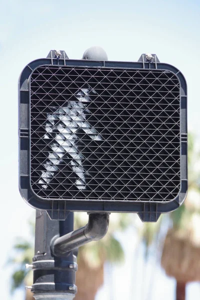 Pedestrian crosswalk traffic signal with a green light walking figure