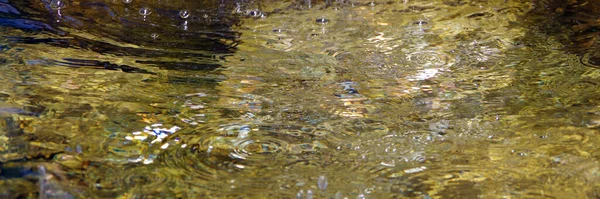 Reflecterende Fontein Water Oppervlak Een Gouden Tint — Stockfoto