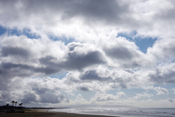 Storm clouds over a wide beach and ocean on a California winter day