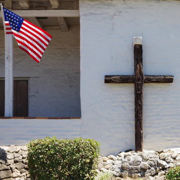 US flag and a Christian cross together on a historic mission church