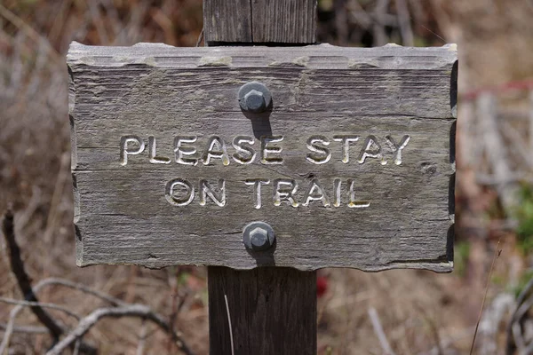 PLEASE STAY ON TRAIL sign in a public nature park