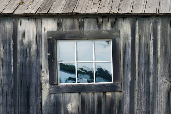 Window in an old weathered wooden shack