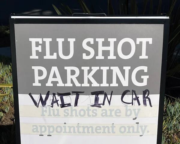 Ücretsiz Grip Aşıları Için Bir Kliniğe Park Tabelası Asılmış — Stok fotoğraf