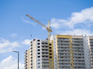 Krasnoyarsk. Rusya - 1 Temmuz 2021: Crane yeni bir meskun bina inşa ediyor. Gökyüzüne karşı inşaat alanı. Güneşli yaz günü