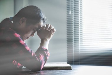 Hristiyan hayatı, Tanrı 'ya dua etmek. Daha iyi bir hayat dilemek için Tanrı 'ya dua et. Kadın elleri İncil 'le Tanrı' ya dua ediyor. Bağışlanmak için yalvarıyor ve iyiliğe inanıyordu..