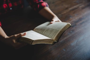 Sabahleyin açık incili kapat. Pencere ışığıyla ahşap masanın üzerinde.