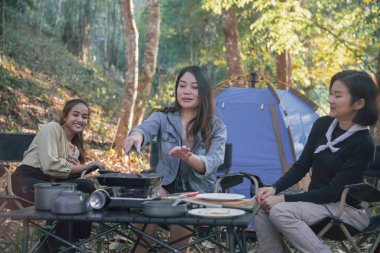 En iyi üç arkadaş kampa gider, sohbet eder, yemek yapar, kamp kavramının tadını çıkarırlar.