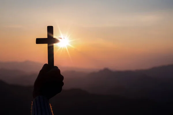 Menschliche Hand Hält Kreuz Mit Hellem Sonnenuntergang Hintergrund Christliches Konzept — Stockfoto