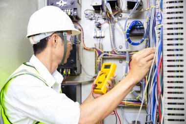 Elektrik mühendisi, kabine kontrolündeki voltaj ve elektrik hattının akımını ölçen bir testçi..