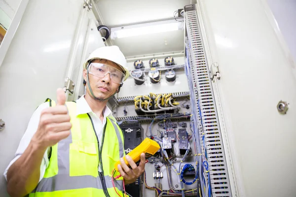 Electrician engineer work at Relay protection system. Bay control unit. Medium voltage switchgear.