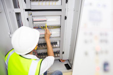Elektrik mühendisi, kabine kontrolündeki voltaj ve elektrik hattının akımını ölçen bir testçi..