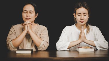  İbadet eden iki kadın inanıyor. Yumuşak odaklanma, dua etme ve evde birlikte dua etme. adanmışlık ya da dua toplantısı kavramı.