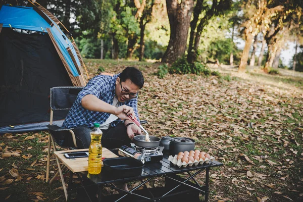 Man On Camping Holiday Frying Egg In Pan