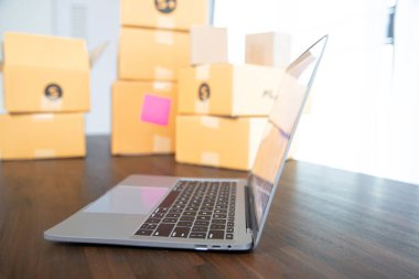 İş yerinde dizüstü bilgisayar var. Çevrimiçi satış, e-ticaret, paketleme konsepti, sabah ışığı