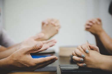  Dua eden bir grup insan inanıyor. Yumuşak odaklanma, dua etme ve evde birlikte dua etme. adanmışlık ya da dua toplantısı kavramı.