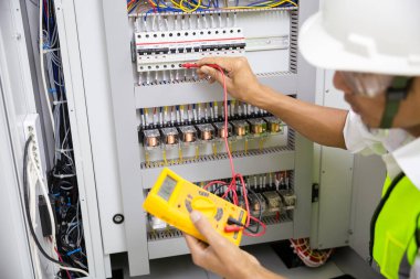 Elektrik mühendisi, kabine kontrolündeki voltaj ve elektrik hattının akımını ölçen bir testçi..