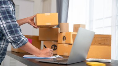 İş kadını sahibi cep telefonuyla konuşuyor ve sipariş alıyor. Merkez büroda çalışan bayan girişimci telefon siparişini doğruladı.