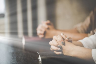  İbadet eden iki kadın inanıyor. Yumuşak odaklanma, dua etme ve evde birlikte dua etme. adanmışlık ya da dua toplantısı kavramı.