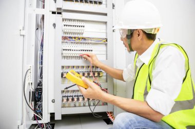 Elektrik mühendisi, kabine kontrolündeki voltaj ve elektrik hattının akımını ölçen bir testçi..