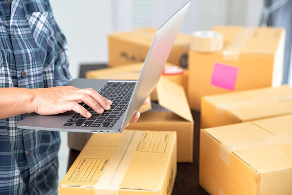 Small entrepreneurs start their SME business at home by arranging their products in parcel boxes. The idea is to start selling online with laptops for taking orders and shipping.