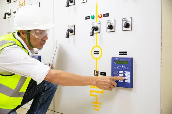 Electrician engineer work at Relay protection system. Bay control unit. Medium voltage switchgear.